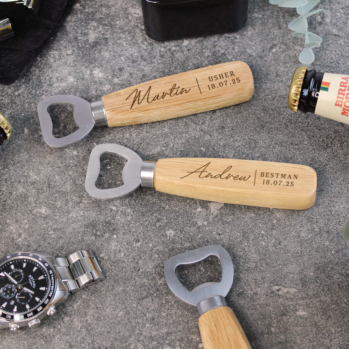 Personalized bottle openers with wooden handles on a concrete surface.