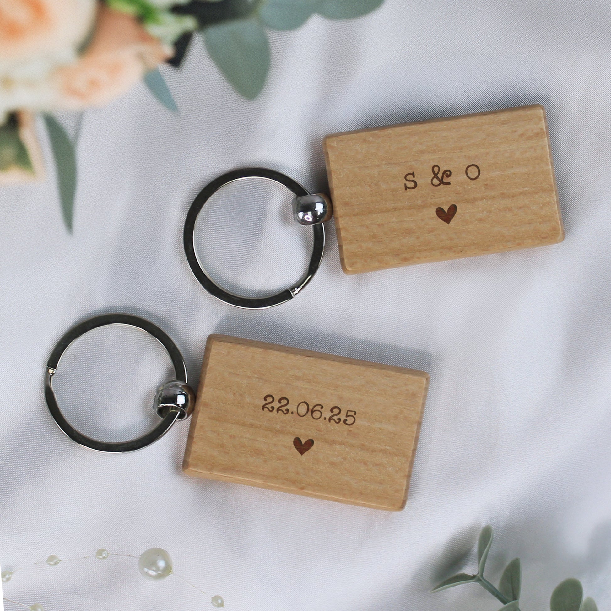 Two wooden keychains with engraved text on a light background