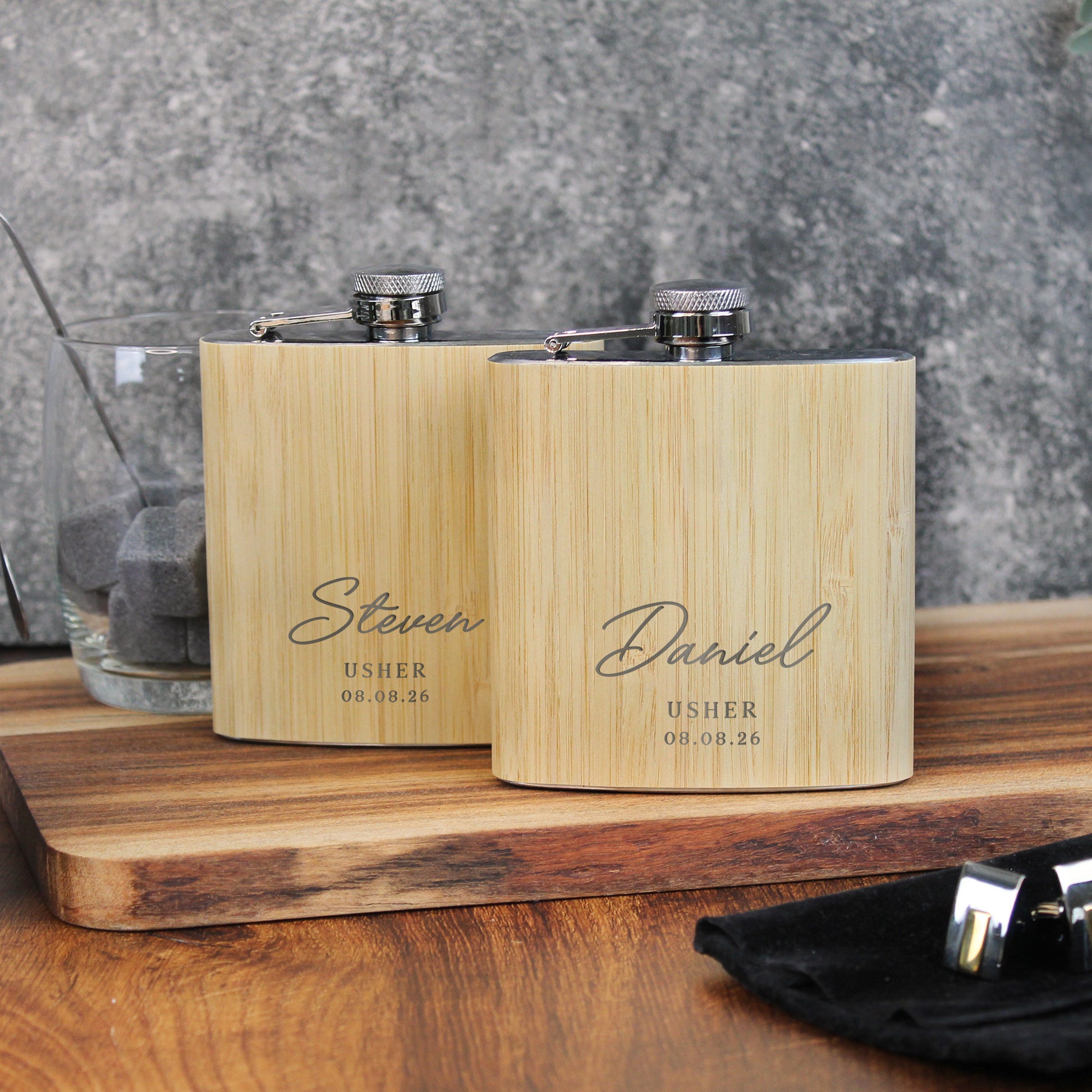 Two wooden flasks with engraved names on a wooden surface.