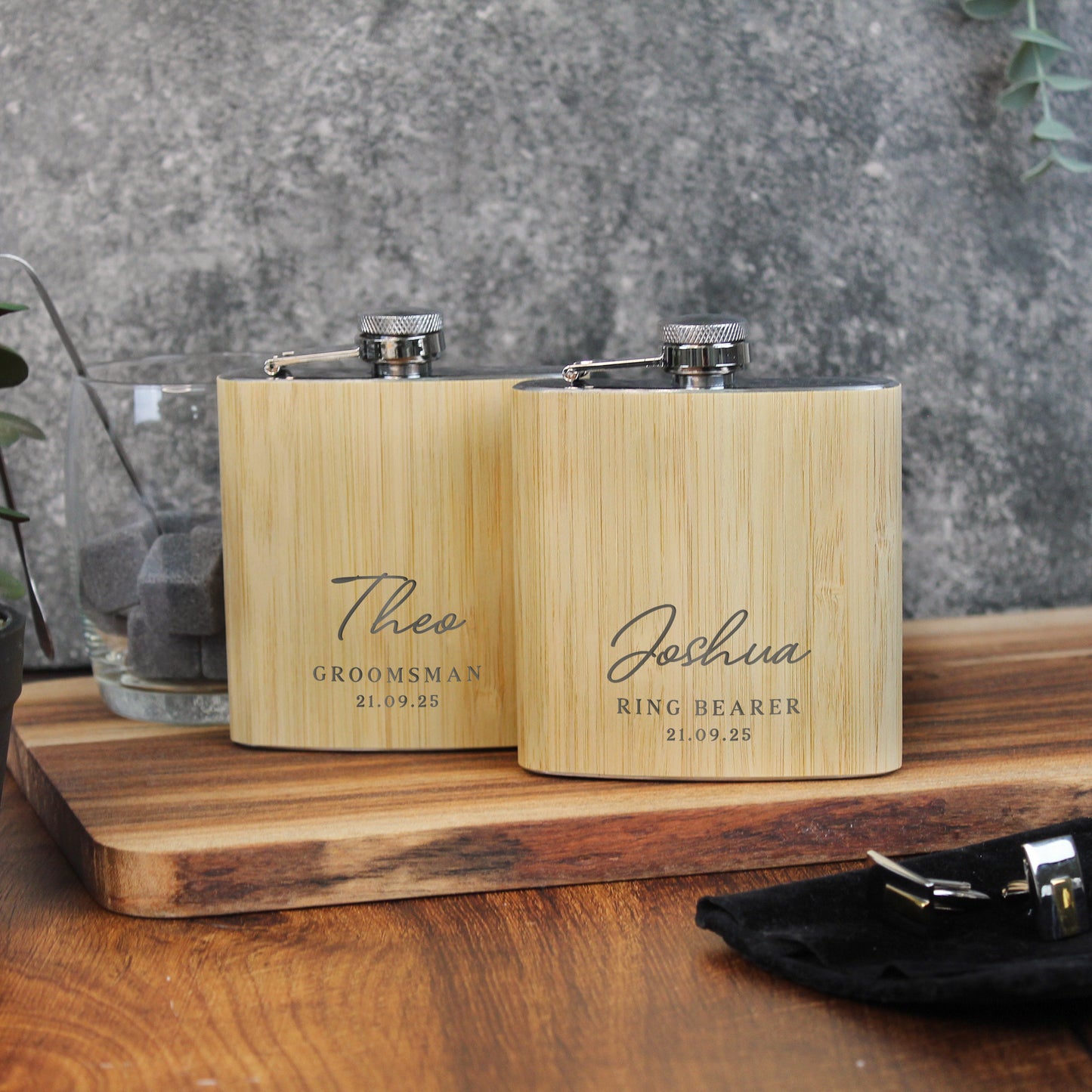 Two wooden flasks with engraved names on a wooden surface.
